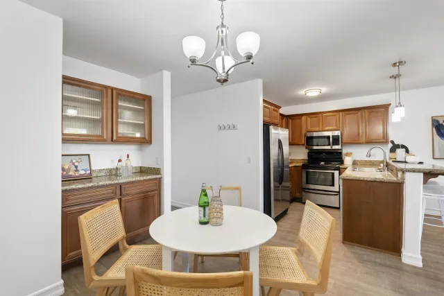 a kitchen with refrigerator a sink and chairs