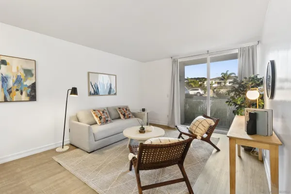 a living room with furniture a flat screen tv and a table