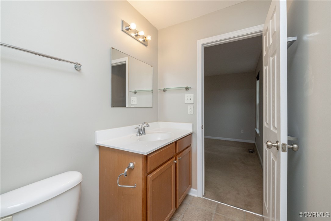 5125 Glenbeigh Road Richmond, VA 23234 - Photo 32 of 40 a bathroom with a sink a toilet a mirror and vanity