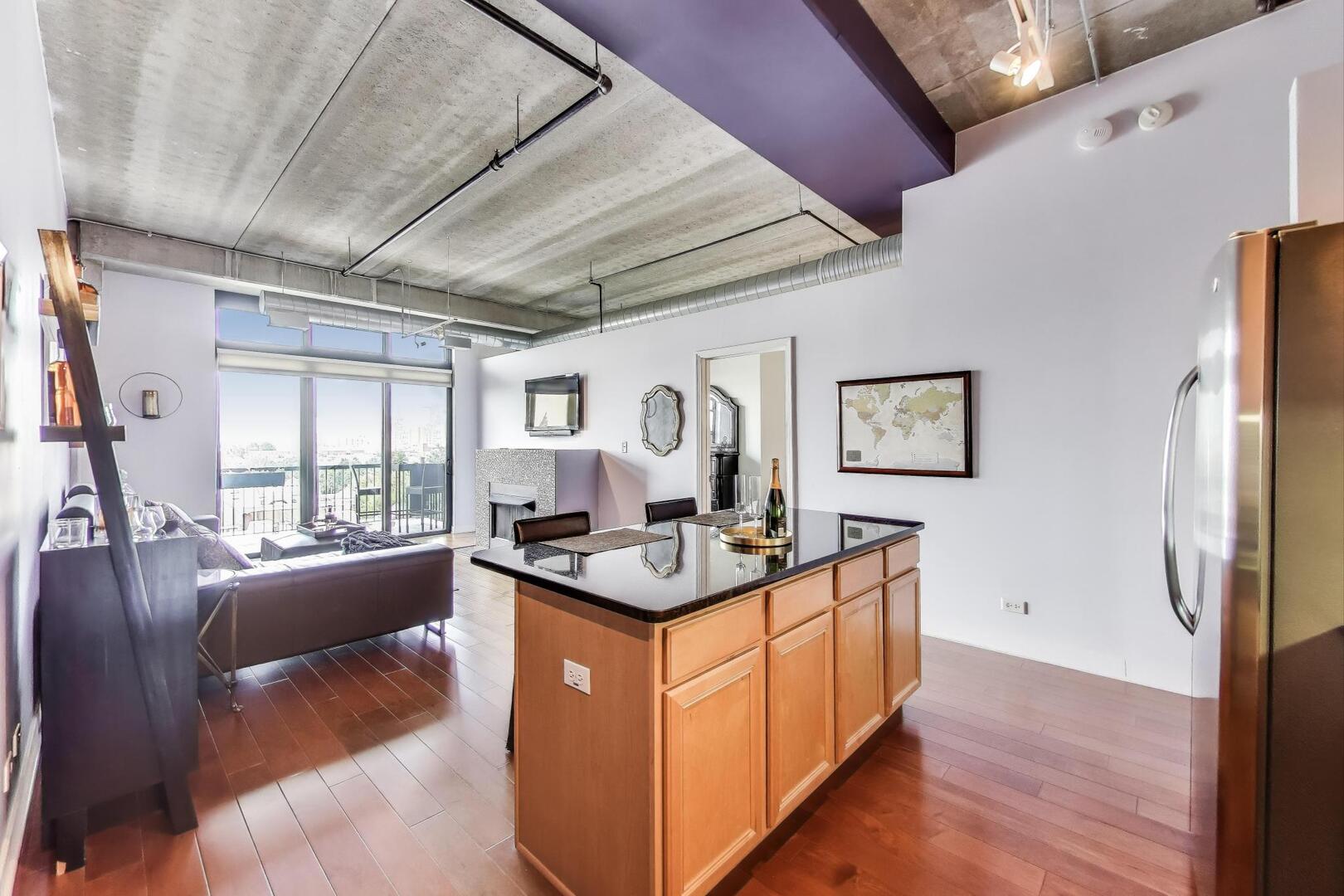 833 West 15th Place, Unit 606W Chicago, IL 60608 - Photo 13 of 47 a view of living room with kitchen island furniture wooden floor and a rug