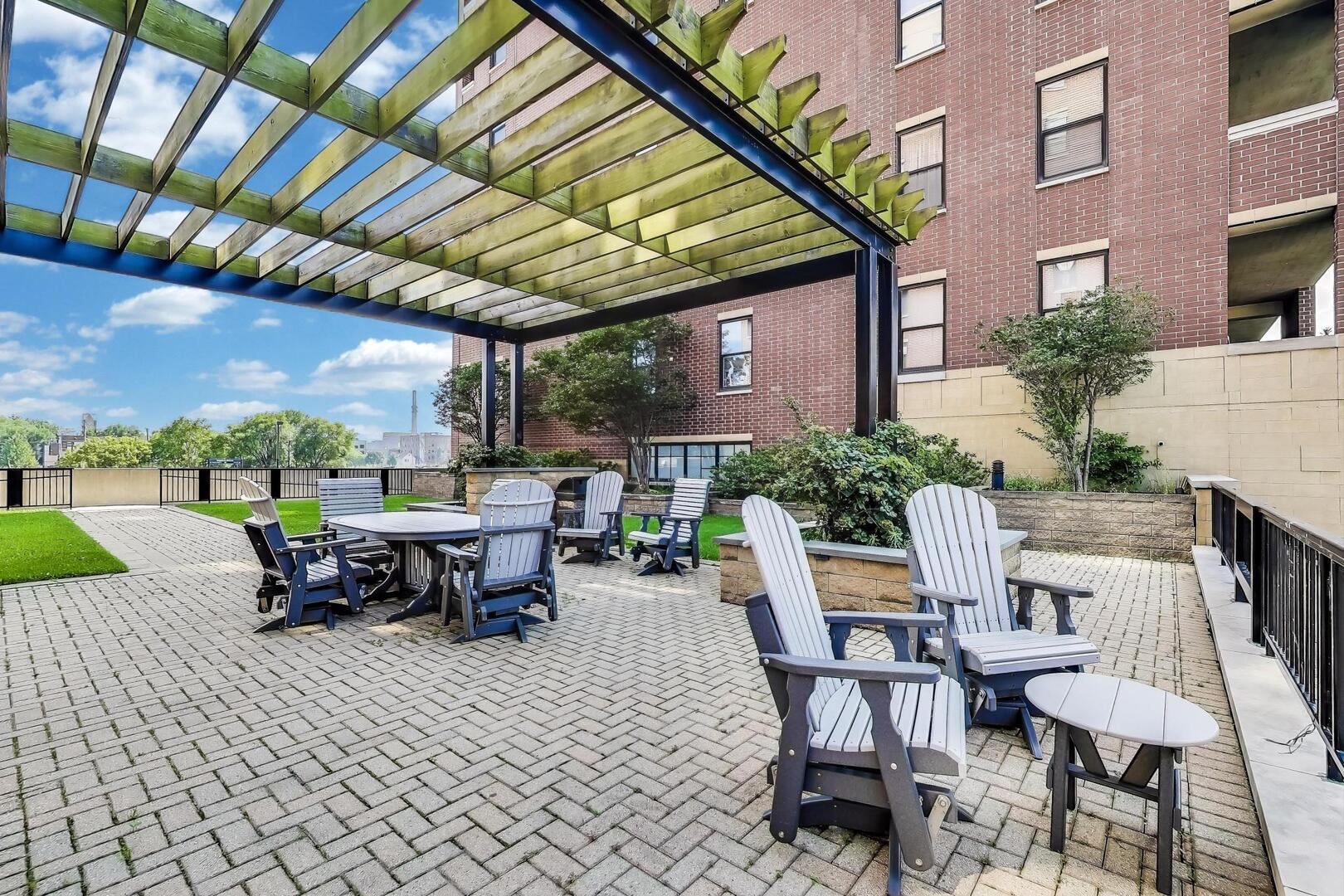833 West 15th Place, Unit 606W Chicago, IL 60608 - Photo 33 of 47 a view of a patio with a dining table and chairs with a barbeque grill and a potted plant