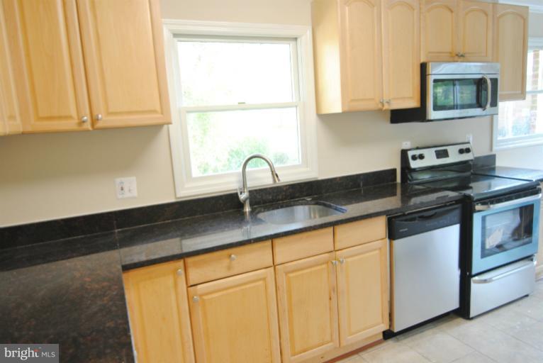a kitchen with granite countertop white cabinets and a sink