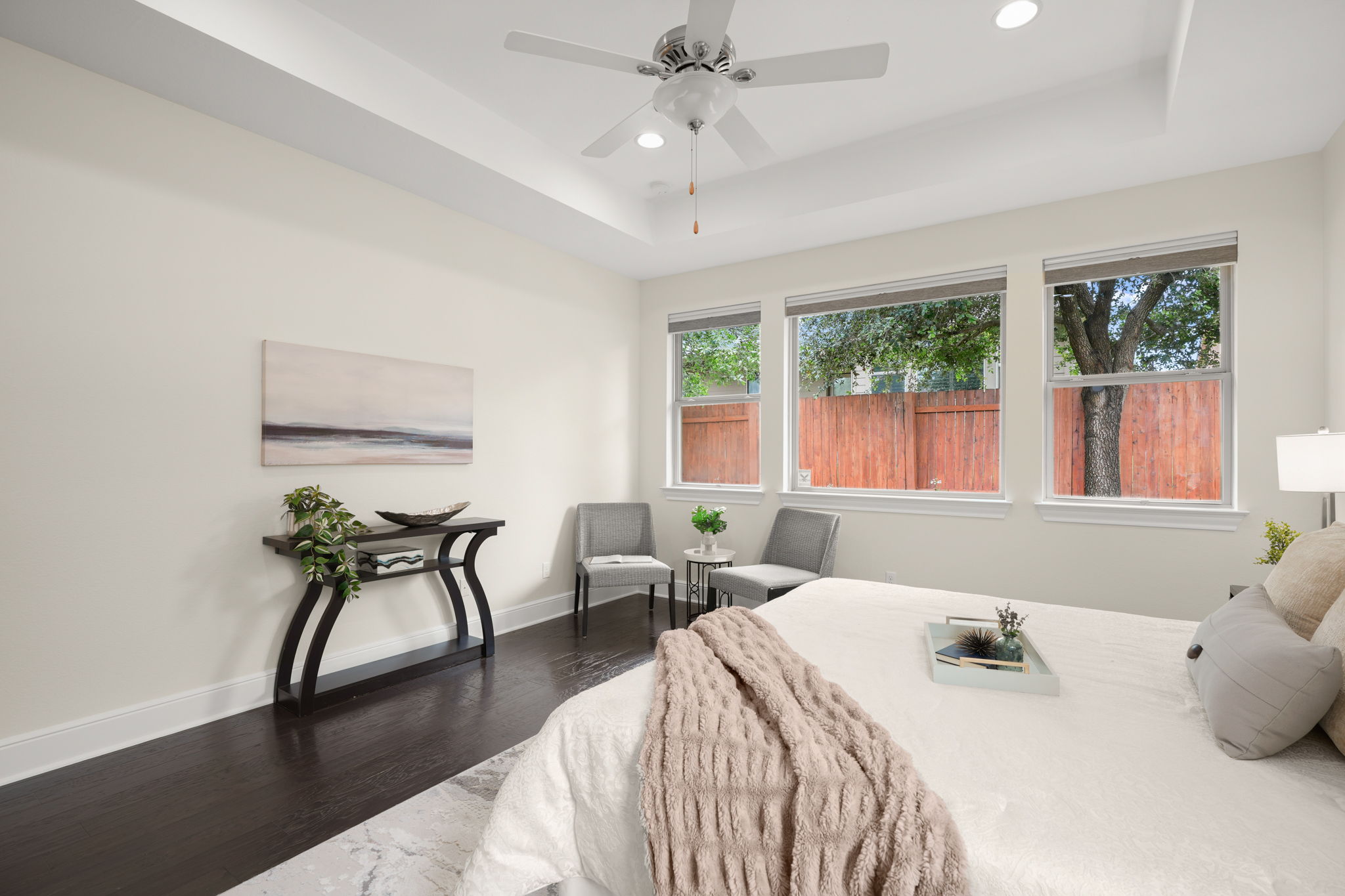 440 Cherokee Rose Circle Georgetown, TX 78626 - Photo 25 of 39 Elegant primary bedroom with rich hardwood floors, ample natural light, and a tray ceiling for an elevated feel.