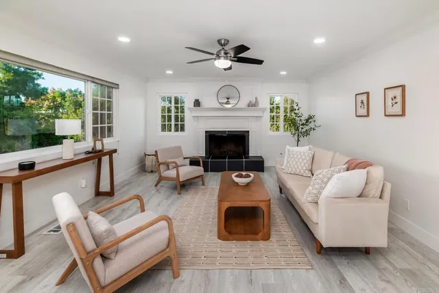 a living room with furniture a fireplace and a floor to ceiling window