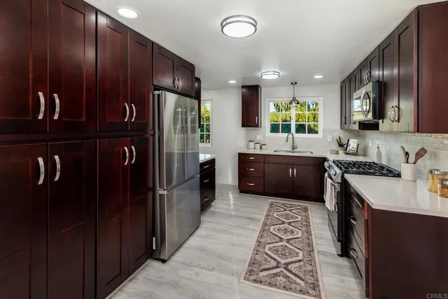 a kitchen with stainless steel appliances granite countertop a refrigerator and a sink