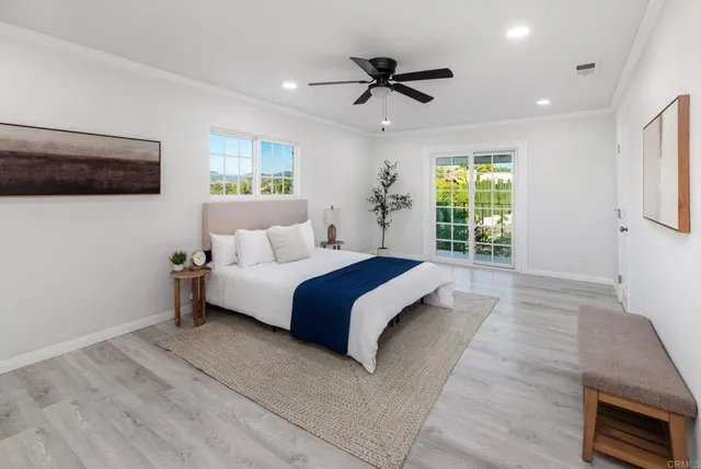 a spacious bedroom with a large bed and a chandelier