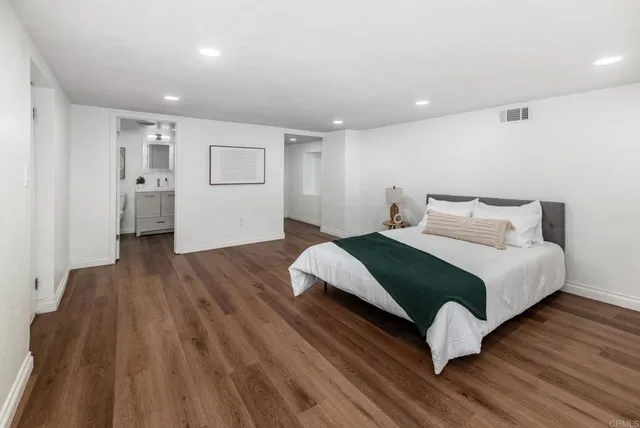 a bedroom with a bed and wooden floor
