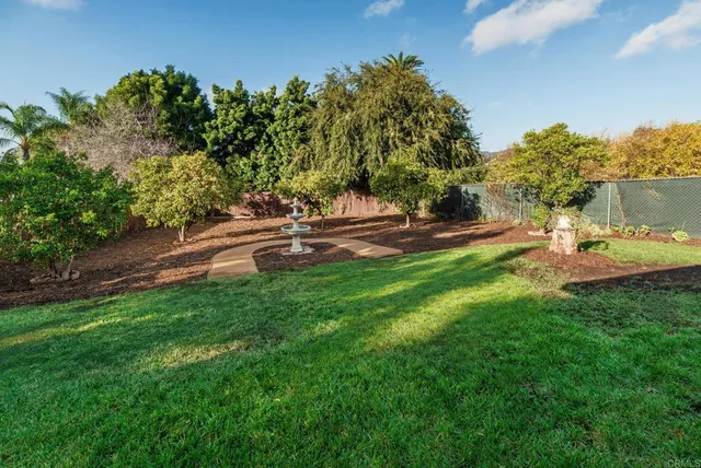 a view of an house with backyard space and a tree