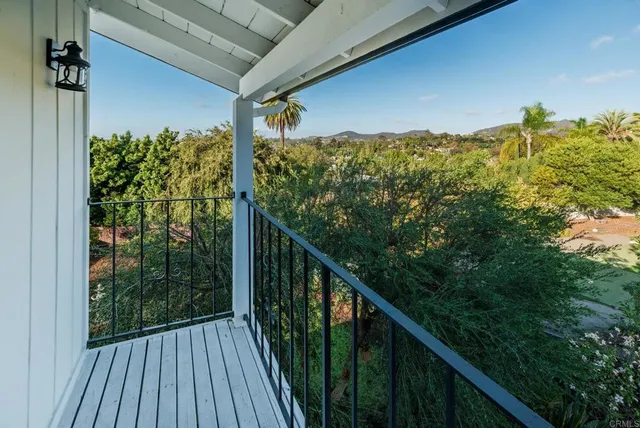 a view of balcony with wooden floor and fence