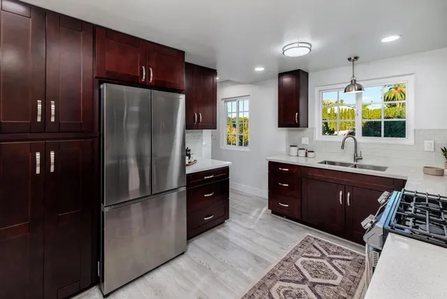 a kitchen with stainless steel appliances granite countertop a refrigerator and a sink