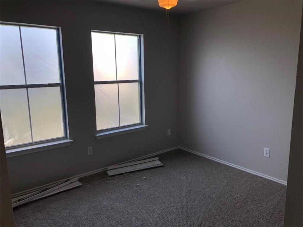 9217 Rowlands Sayle Road Austin, TX 78744 - Photo 9 of 18 Double windows frame views in a carpeted room featuring clean lines.