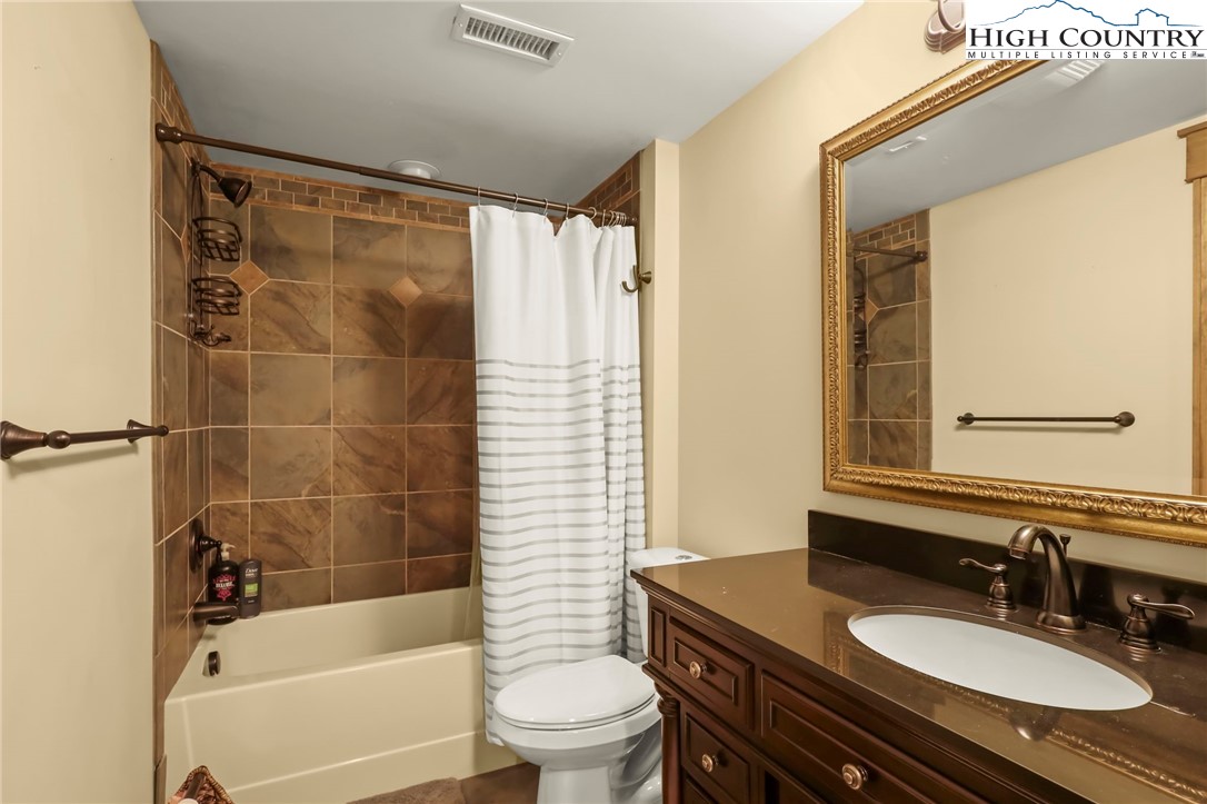 138 South Camp Road, Unit 103 Boone, NC 28607 - Photo 37 of 50 a bathroom with a granite countertop sink toilet a mirror and shower