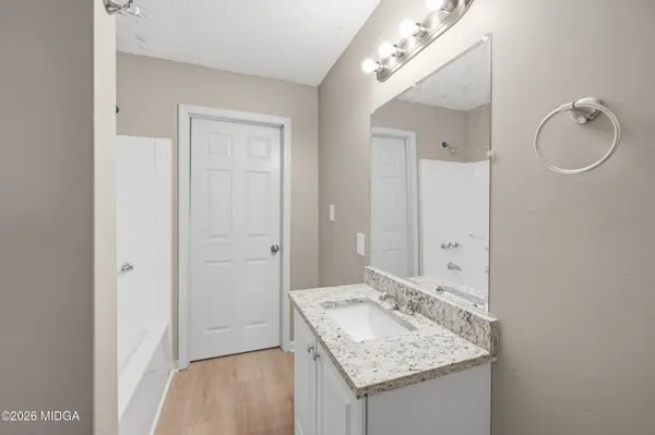 a bathroom with a granite countertop sink a mirror and a vanity