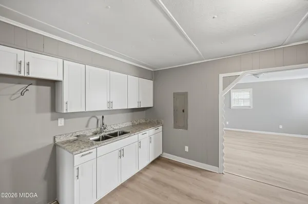 a kitchen with granite countertop white cabinets and white appliances