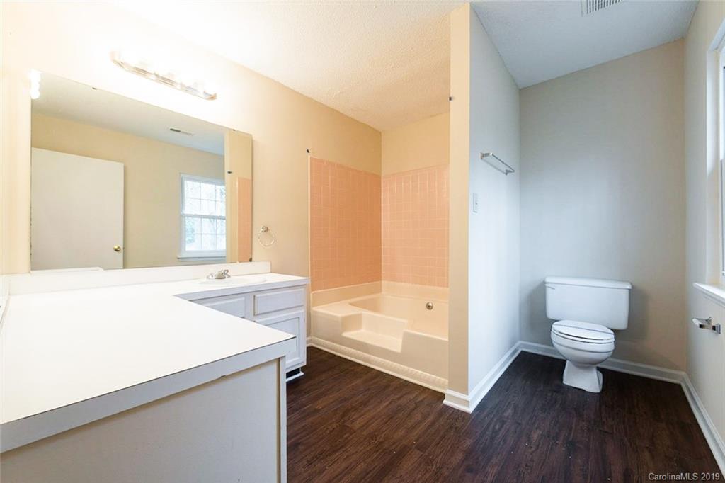 5919 Hunters Crossing Lane Charlotte, NC 28215 - Photo 4 of 14 a spacious bathroom with a sink a toilet and a bathtub