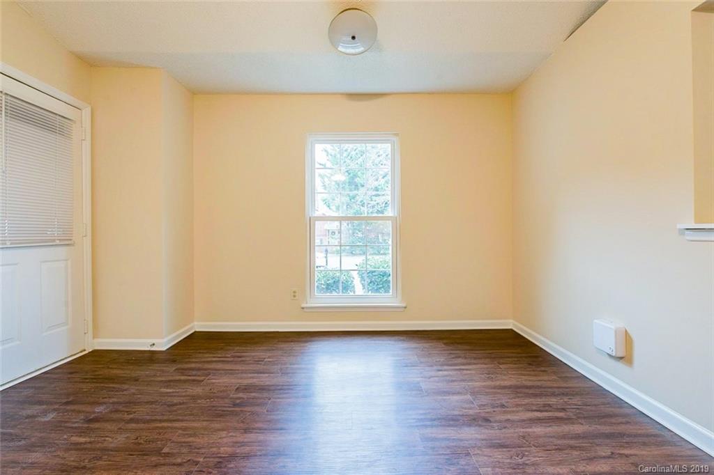 5919 Hunters Crossing Lane Charlotte, NC 28215 - Photo 6 of 14 an empty room with wooden floor and windows