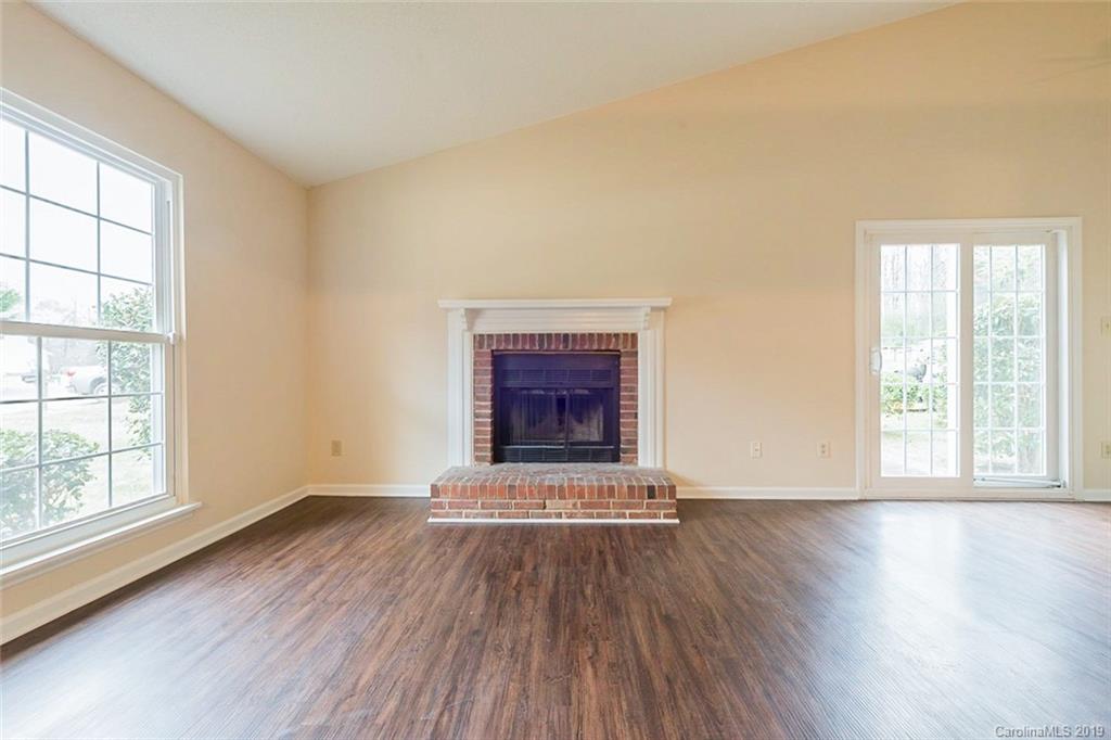 5919 Hunters Crossing Lane Charlotte, NC 28215 - Photo 7 of 14 an empty room with wooden floor and windows