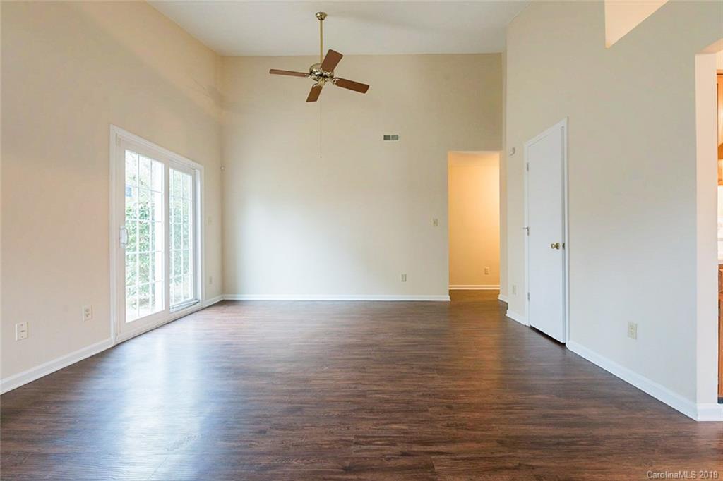 5919 Hunters Crossing Lane Charlotte, NC 28215 - Photo 8 of 14 wooden floor in an empty room with a window