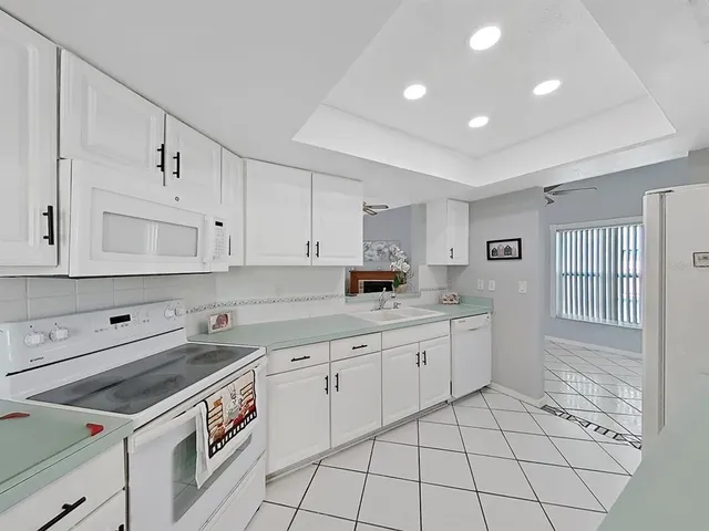 a kitchen with granite countertop white cabinets and white appliances