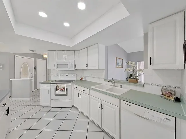 a kitchen with white cabinets appliances and a sink