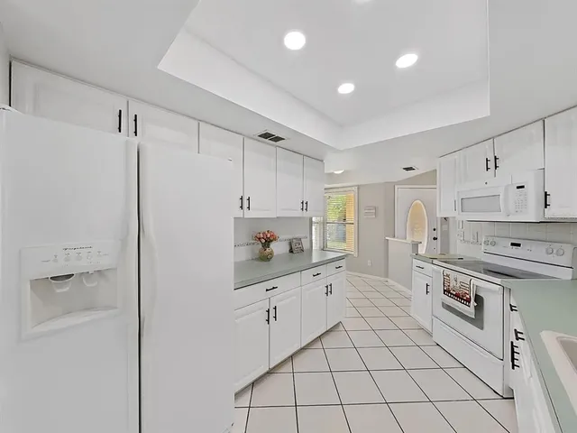 a kitchen with white cabinets and white appliances