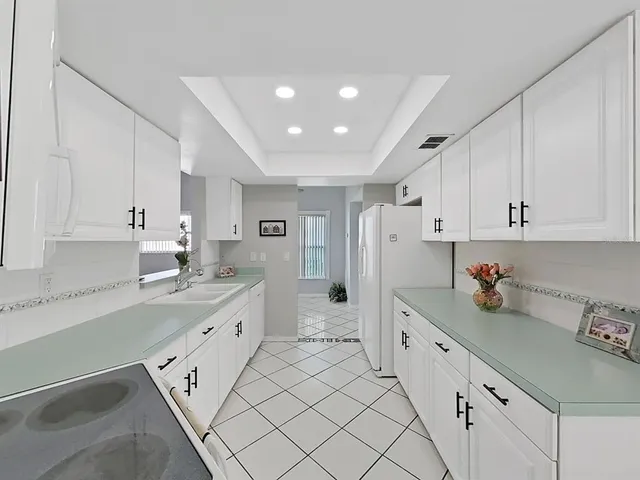 a kitchen with white cabinets and white appliances