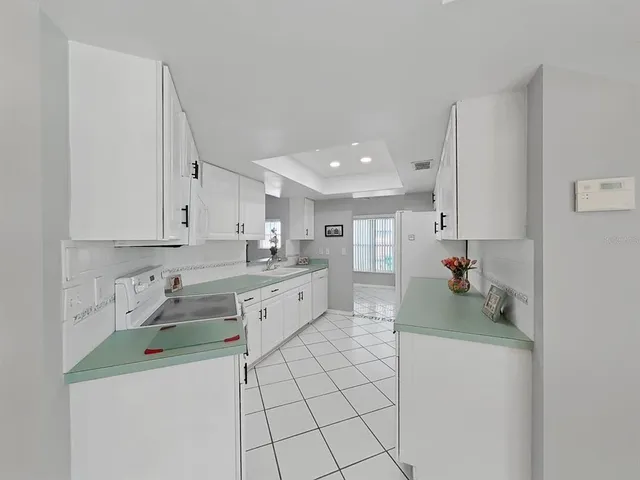 a kitchen with white cabinets and white appliances