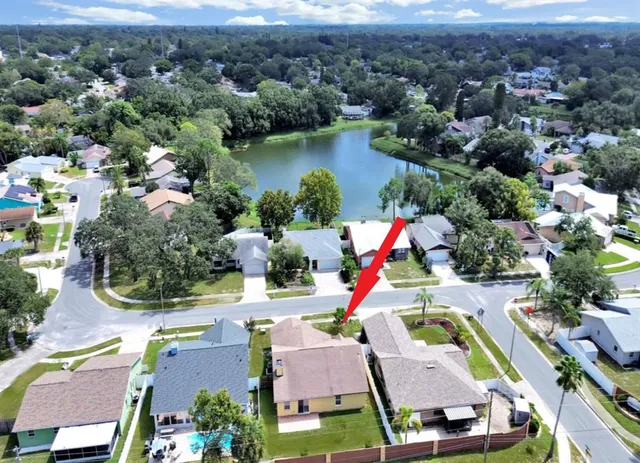 an aerial view of residential houses with outdoor space and lake view