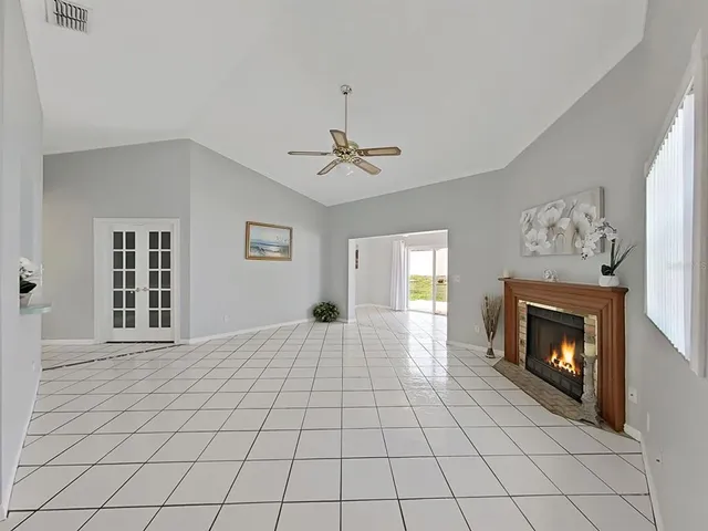 a view of an empty room with window and fireplace