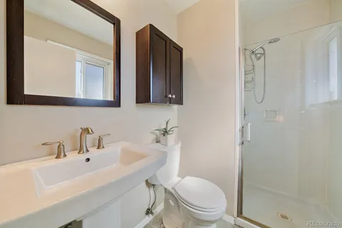 a bathroom with a sink a toilet and shower