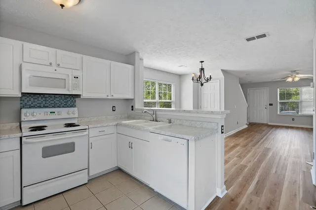 a kitchen with granite countertop a sink stove and cabinets