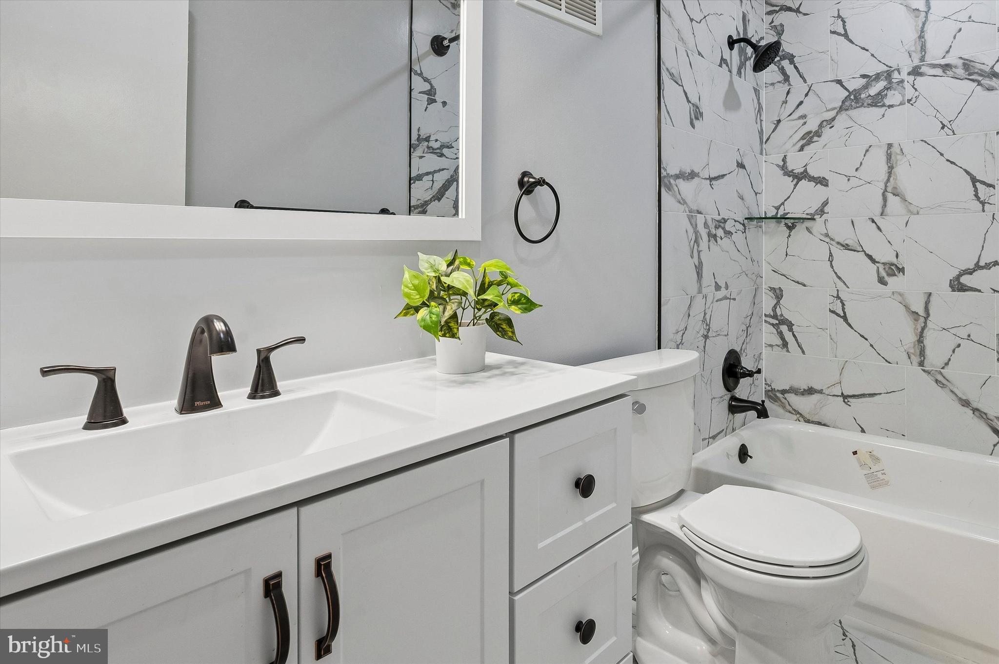 6129 Spruce Street Philadelphia, PA 19139 - Photo 11 of 18 a bathroom with a granite countertop sink and a toilet