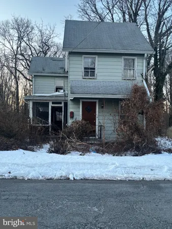 a front view of a house with a yard covered with snow