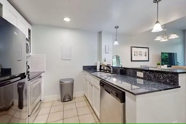 a kitchen with stainless steel appliances granite countertop a sink stove and cabinets