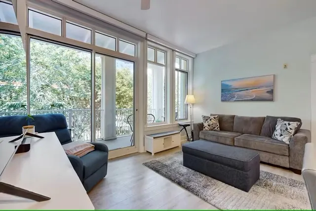 a living room with furniture and large windows