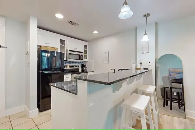 a large kitchen with a large counter top appliances and cabinets