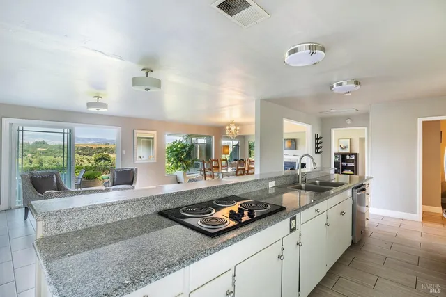 a large kitchen with granite countertop a sink and a counter top space