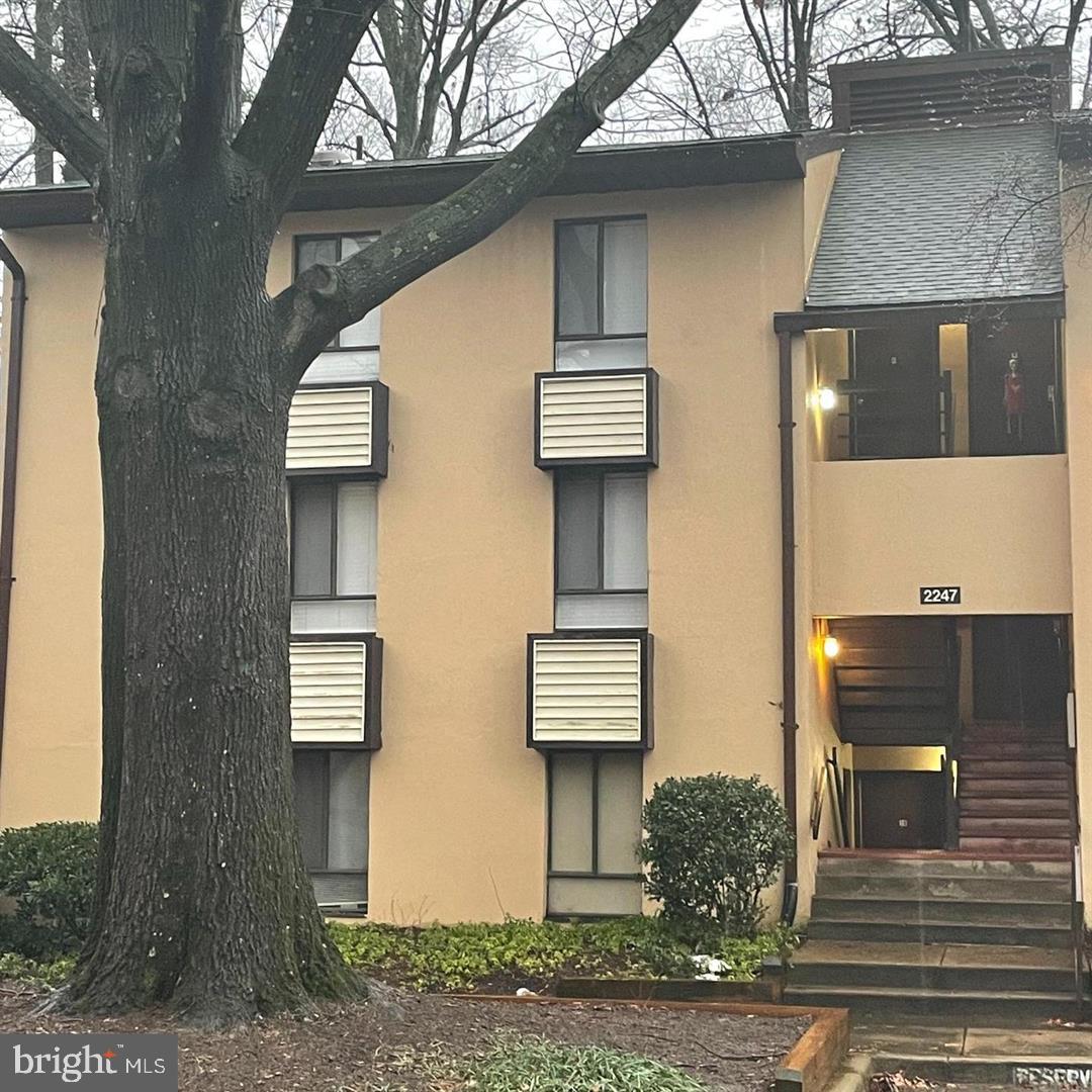 2247 Castle Rock Square, Unit 1B Reston, VA 20191 - Photo 1 of 26 a front view of a house with street