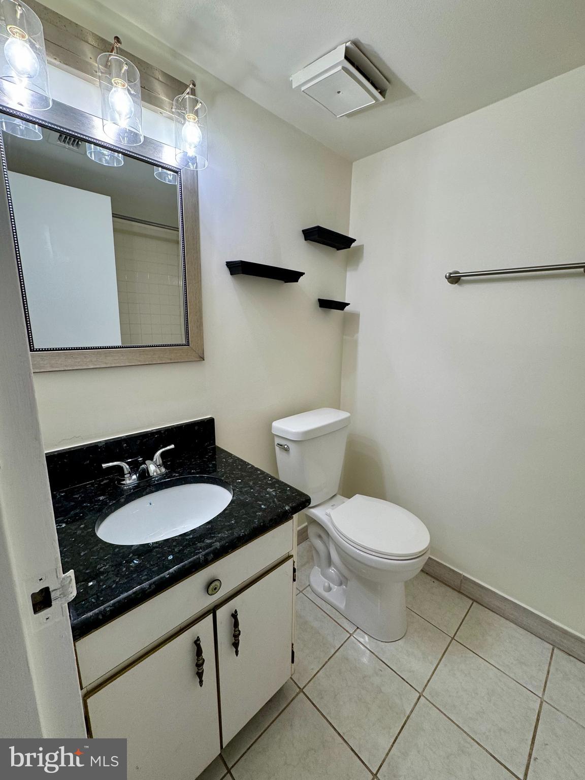 2247 Castle Rock Square, Unit 1B Reston, VA 20191 - Photo 16 of 26 a bathroom with a granite countertop sink mirror vanity and toilet
