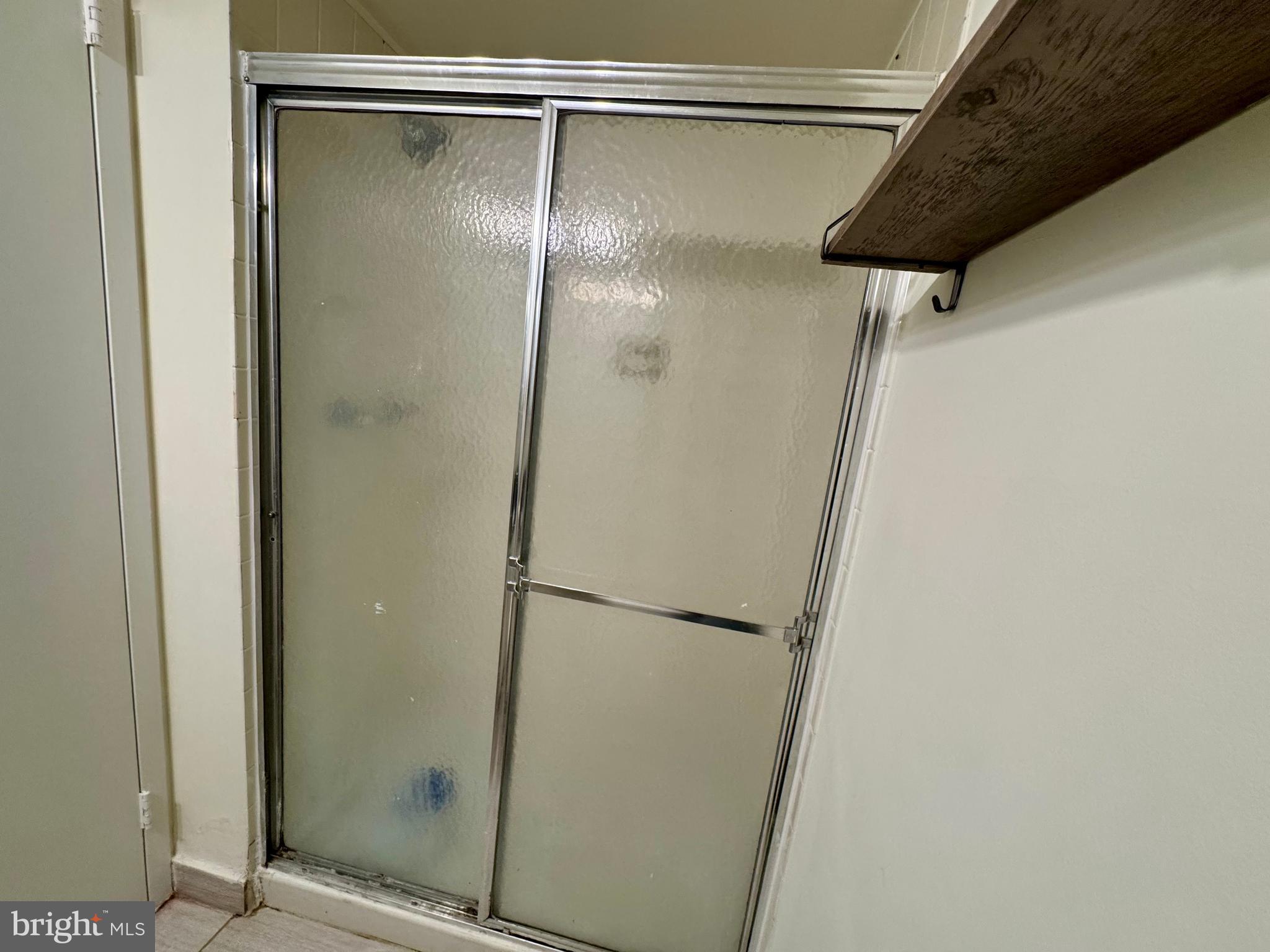 2247 Castle Rock Square, Unit 1B Reston, VA 20191 - Photo 26 of 26 a bathroom with a glass shower door