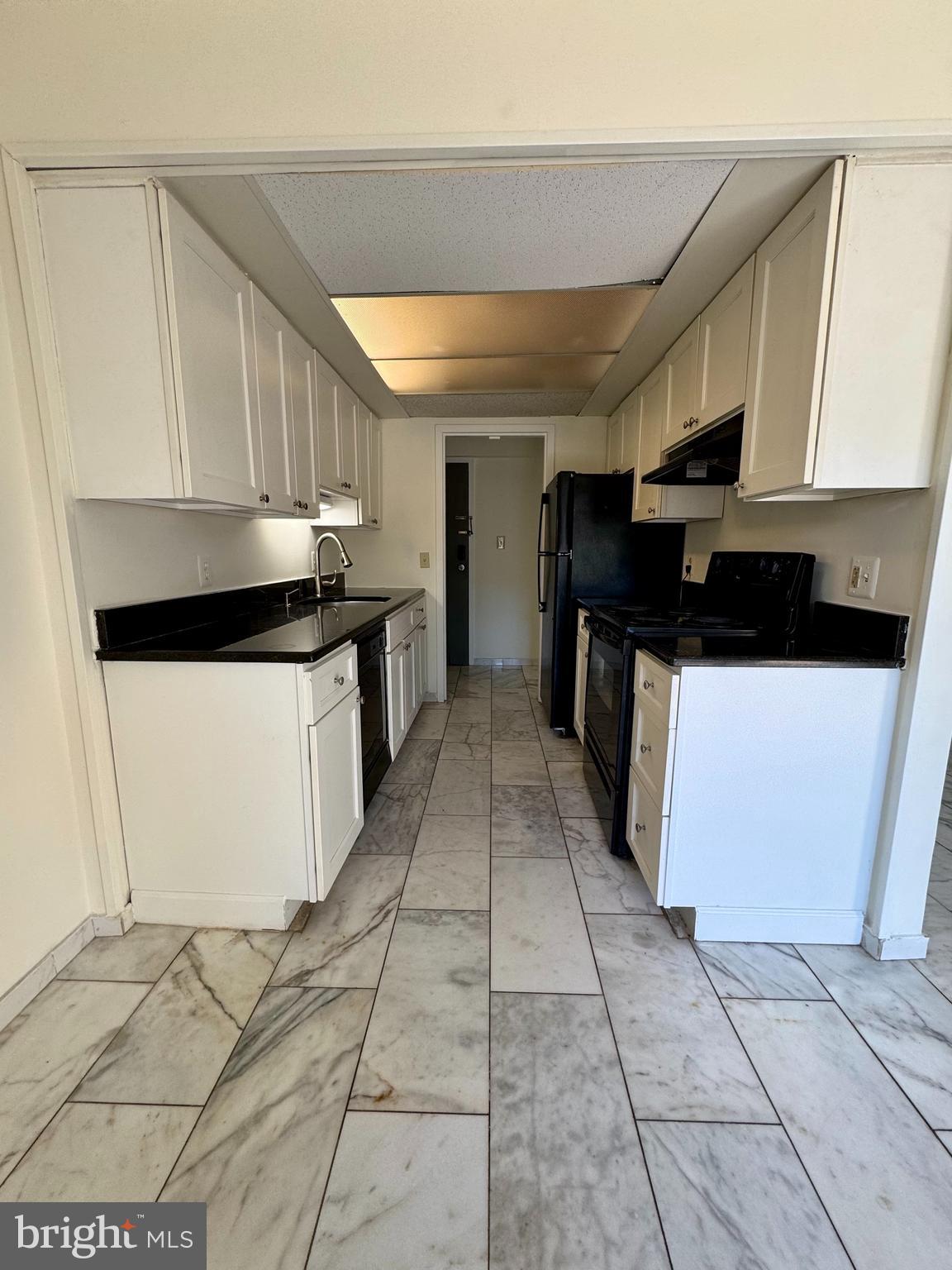 2247 Castle Rock Square, Unit 1B Reston, VA 20191 - Photo 9 of 26 a kitchen with stainless steel appliances a sink a stove top oven a cabinets and a refrigerator