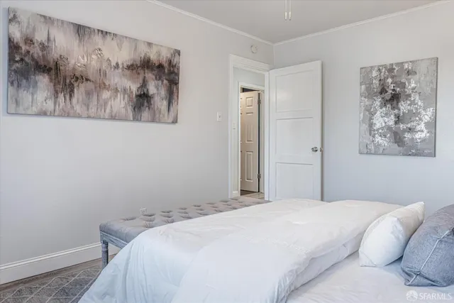 a bedroom with a bed and painting on the wall