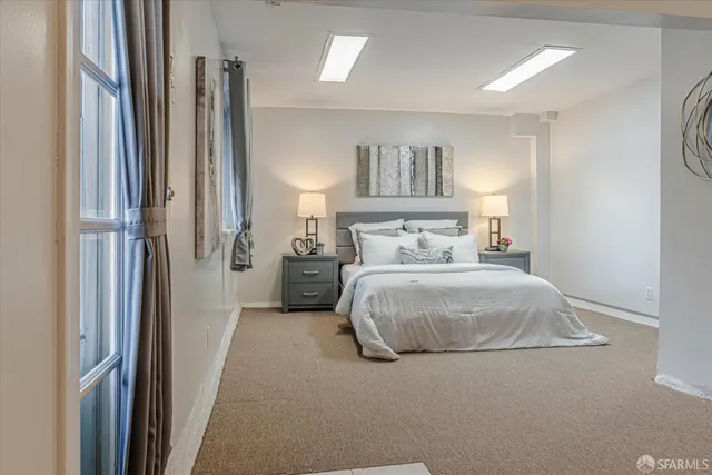 a bedroom with a bed and a painting on the wall