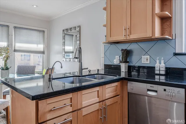 a kitchen with granite countertop a sink a stove and cabinets