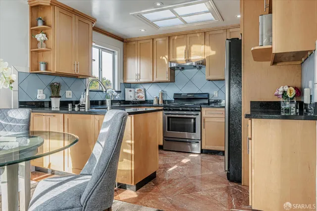 a kitchen with stainless steel appliances granite countertop a stove a sink dishwasher and a refrigerator
