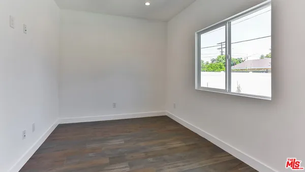 a view of a room that has wooden floor and a window