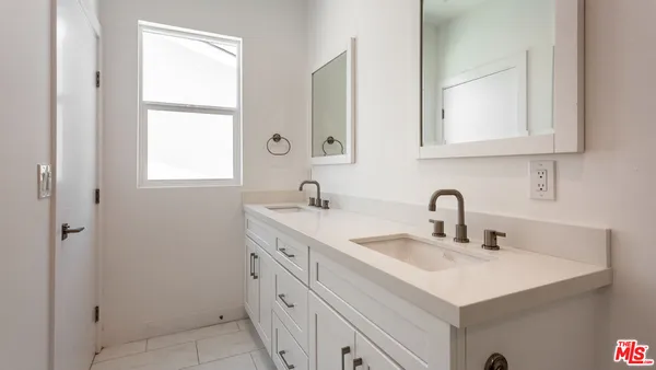 a bathroom with double sink and a mirror