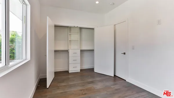 an empty room with closet and wooden floor