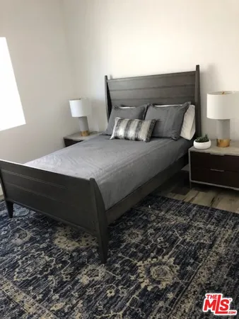 a bedroom with a bed and a night stand