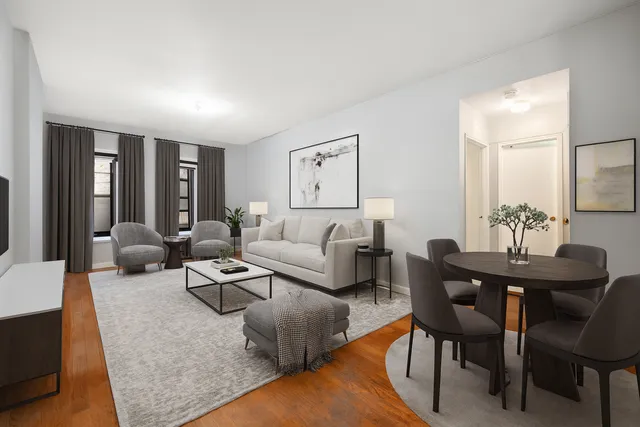 a living room with furniture potted plant and open kitchen view